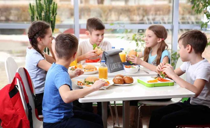 Kids eating lunch together at a table.