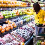 Woman shopping for fruit in a grocery store.