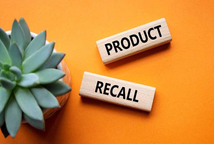 "Product recall" sign near succulent on orange background.