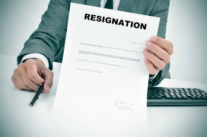 Person holding resignation letter at desk