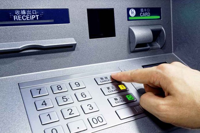 Person pressing button on an ATM keypad.