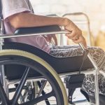 Person sitting in a wheelchair indoors.