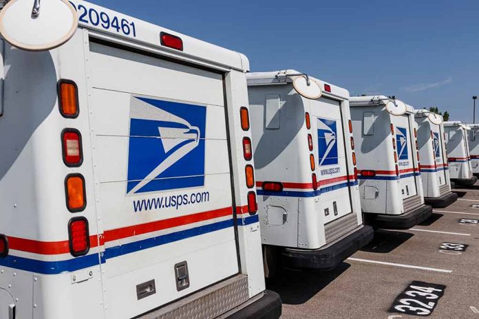 Row of USPS mail trucks parked in lot.