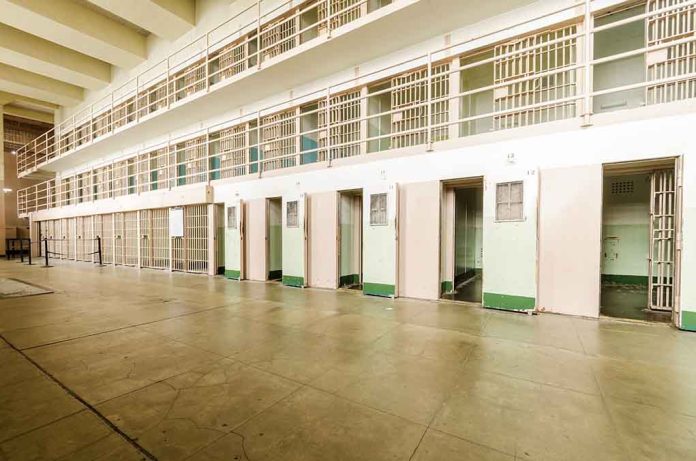 Empty prison cells with open doors, two-story layout.