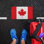 Shoes and bag beside painted Canadian flag.