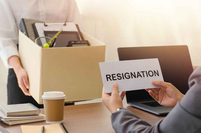 Person holding resignation letter, another carrying a box.