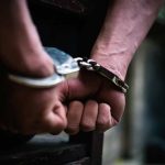 Hands in handcuffs behind back.