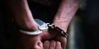 Hands in handcuffs behind back.