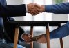 Handshake above table money exchange below table