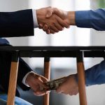 Handshake above table money exchange below table