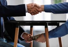 Handshake above table money exchange below table