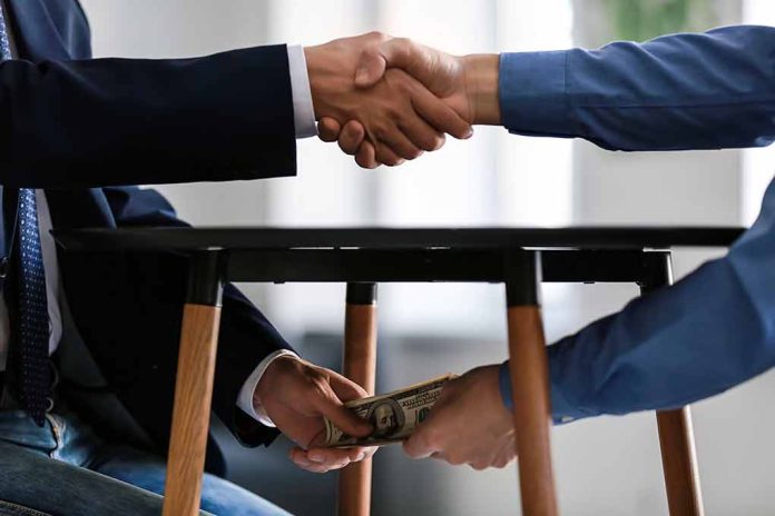 1225177960 featured image Handshake above table money exchange below table