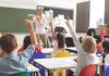 Children raising hands in classroom