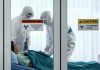 Healthcare workers in protective gear in quarantine room