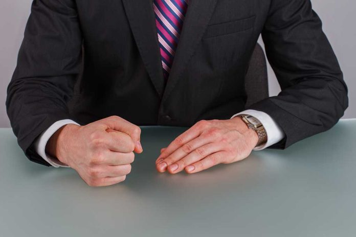 1826394008 featured image Person in suit with clenched fist on table