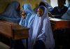 Girls in checkered hijabs sitting at school desks