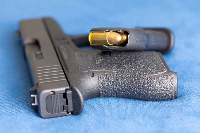 2159542825 featured image Handgun on blue fabric with visible bullet cartridge.