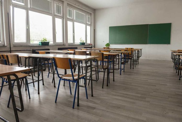 487861393 featured image Empty classroom with desks chairs windows and chalkboard