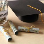 Graduation cap with money rolls and jar labeled Education