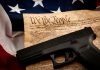 Gun on US Constitution and American flag