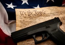 Gun on US Constitution and American flag