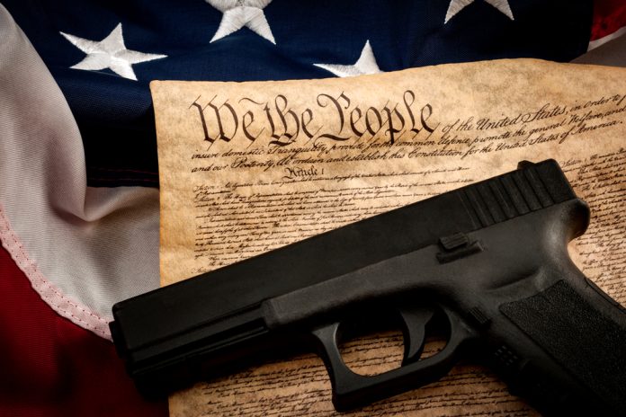 1034579311 featured image Gun on US Constitution and American flag