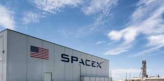 SpaceX building with American flag and launch pad