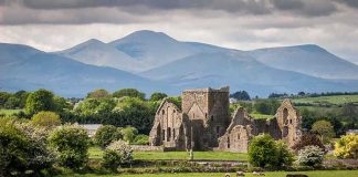 Ruins sheep grazing mountains and cloudy sky