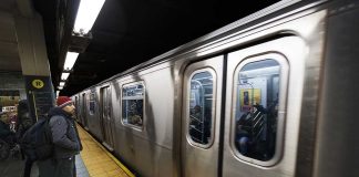 Man waiting at subway platform with departing train