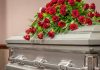 Silver casket with red rose arrangement on top