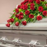 Silver casket with red rose arrangement on top