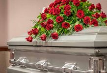 Silver casket with red rose arrangement on top