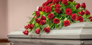 Silver casket with red rose arrangement on top