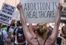 Protestors holding signs about women's rights and healthcare