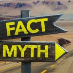 Directional signs labeled Fact and Myth in desert