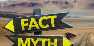 Directional signs labeled Fact and Myth in desert