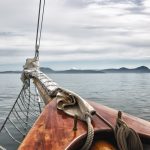 Boat deck with ropes on calm ocean water