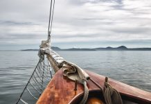 Boat deck with ropes on calm ocean water
