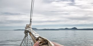 Boat deck with ropes on calm ocean water