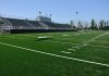 Empty football field with bleachers in background