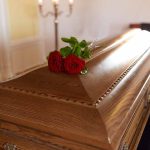 Wooden casket with red roses on top