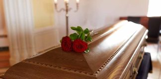 Wooden casket with red roses on top