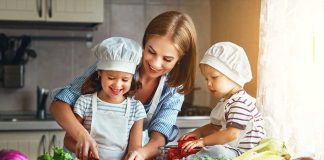 Family cooking together with vegetables in kitchen