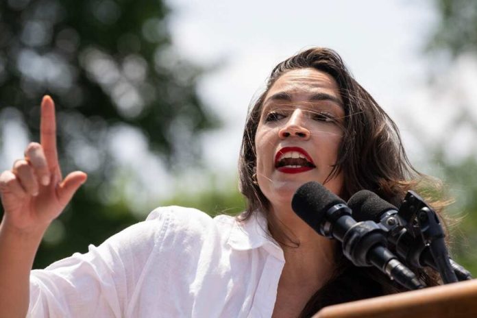 shutterstock_2480447435.jpg featured image Alexandria Ocasio-Cortez speaking at an outdoor event.