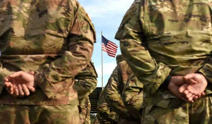 Soldiers stand in formation with American flag in background