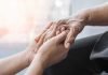 Young hands holding an elderly person's hand
