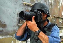 Person in helmet taking photos with a large camera