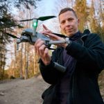 Person holding a drone in a forest