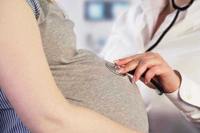 261991445 Doctor uses stethoscope on pregnant womans belly