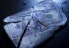 Hundred-dollar bills frozen in cracked ice block